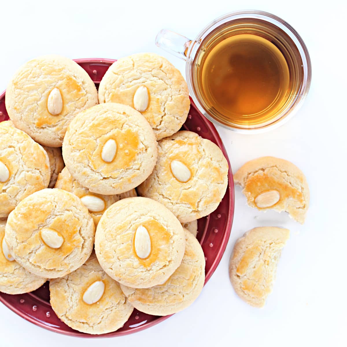 A plate of almond cookies with a cup of tea.