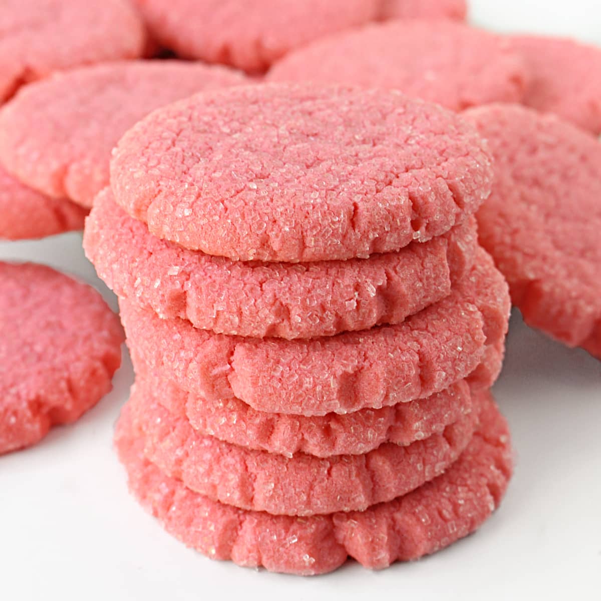 Closeup of a stack of pink sugar cookies  showing the sugar coating and thick edges.