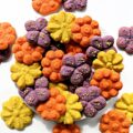 Brightly colored, flower shaped cookies made with a cookie press.