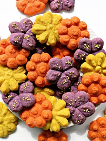 Brightly colored, flower shaped cookies made with a cookie press.