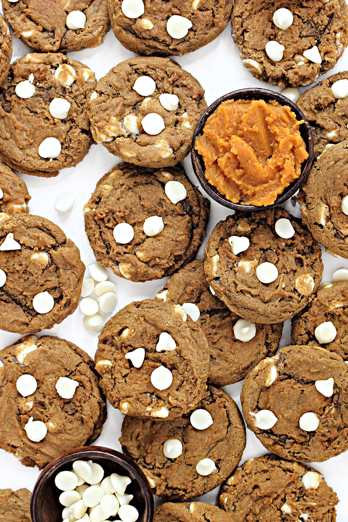 Pumpkin Cookies with cracks and white chocolate chips on top.