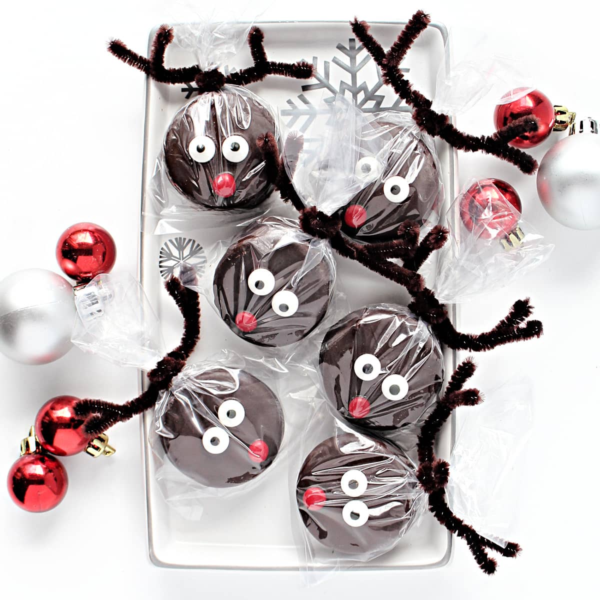 Reindeer Oreos with pipe cleaner antlers on a platter.