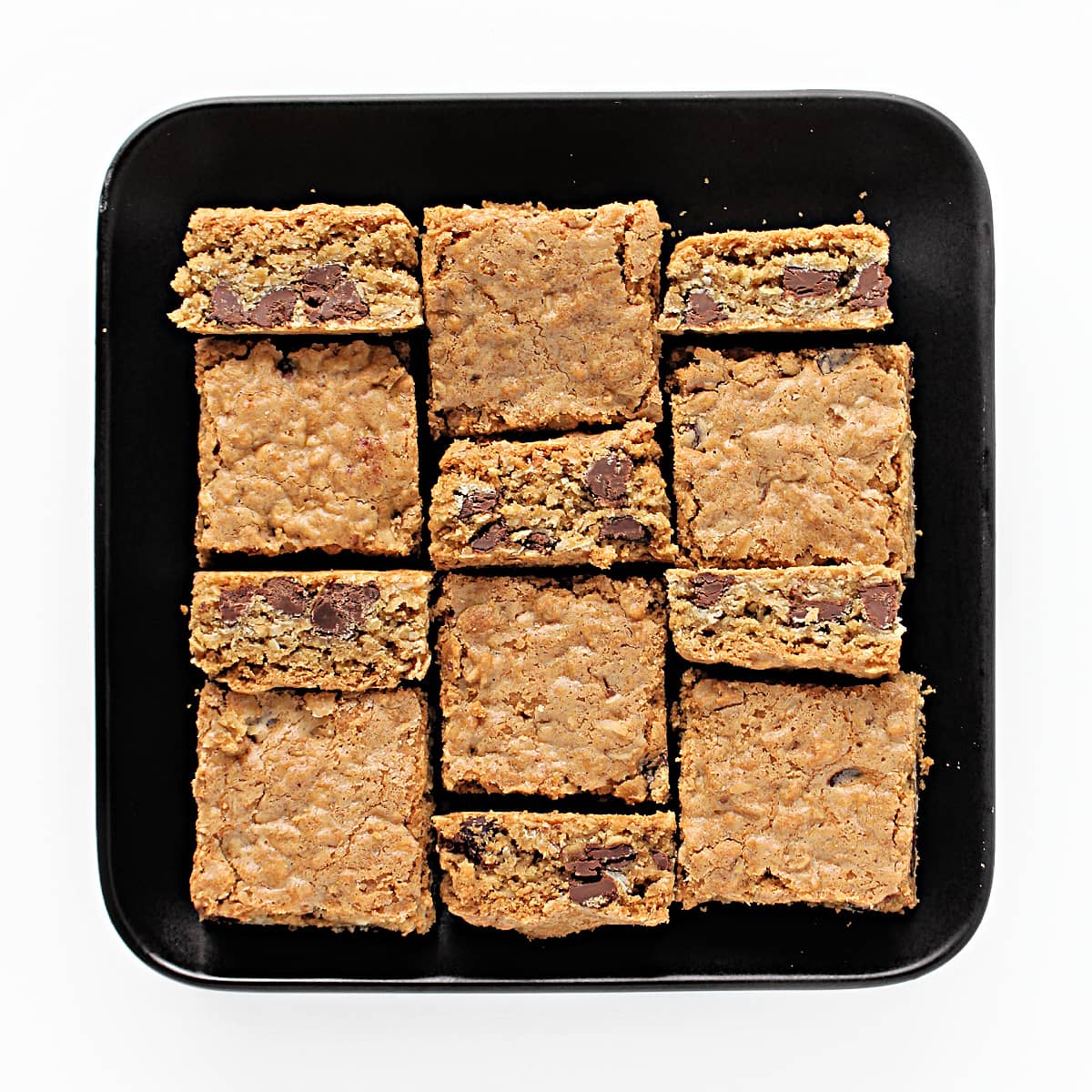 Cut squares of Chocolate Chip Oatmeal Bars on a square serving plate.