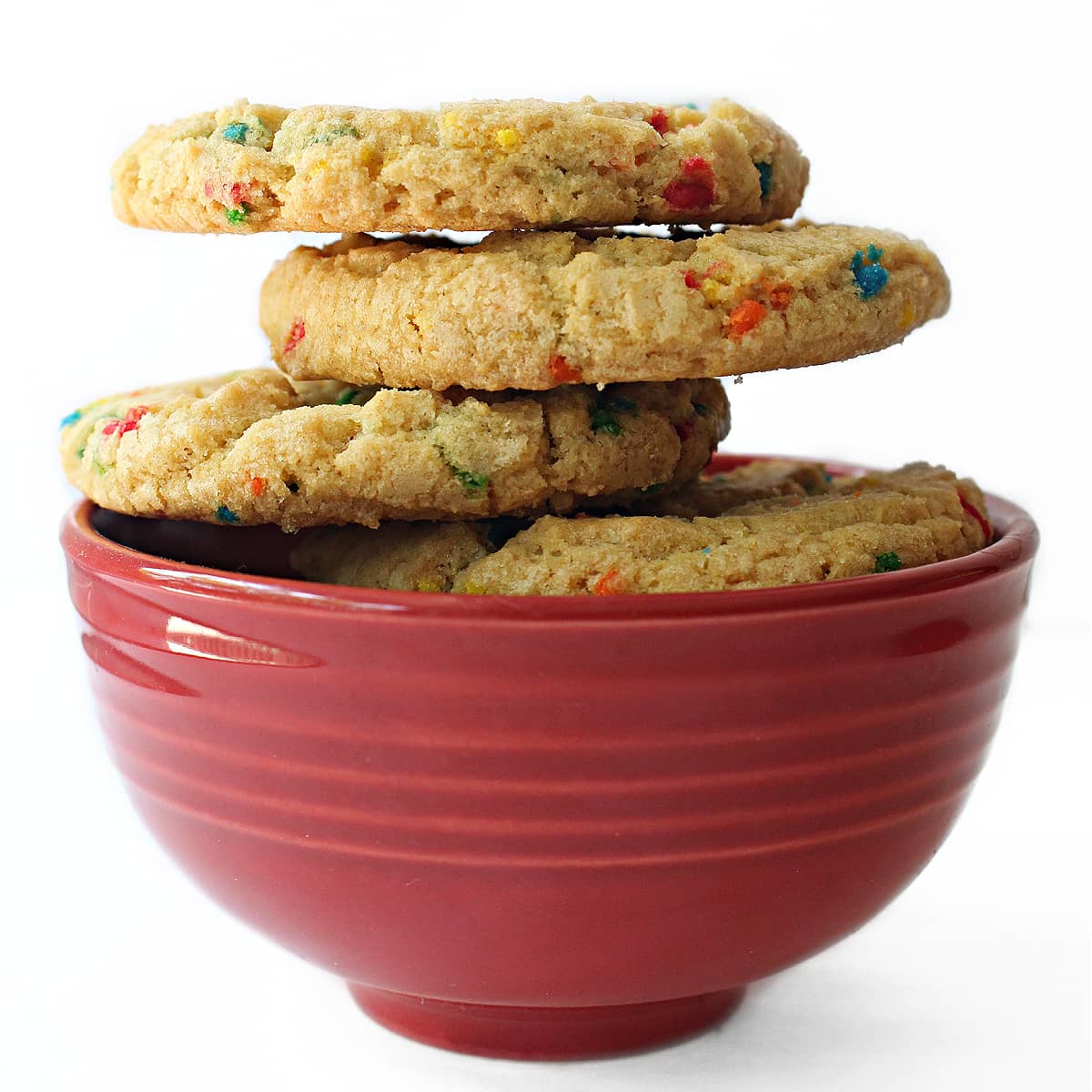 Funfetti Cookies stacked in a bowl showing the thick, rounded edges of the cookies.