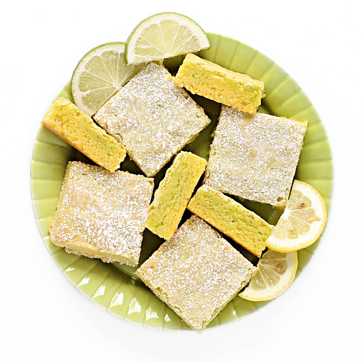 Lemon-Lime Bars on a serving plate showing powdered sugar tops and two layer cut edges.