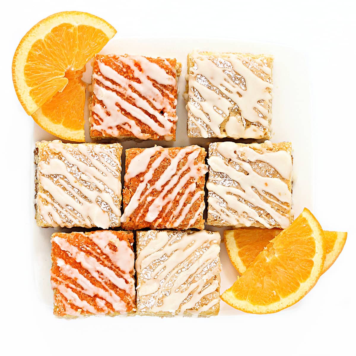 Overhead image of plated orange bars drizzled with icing.