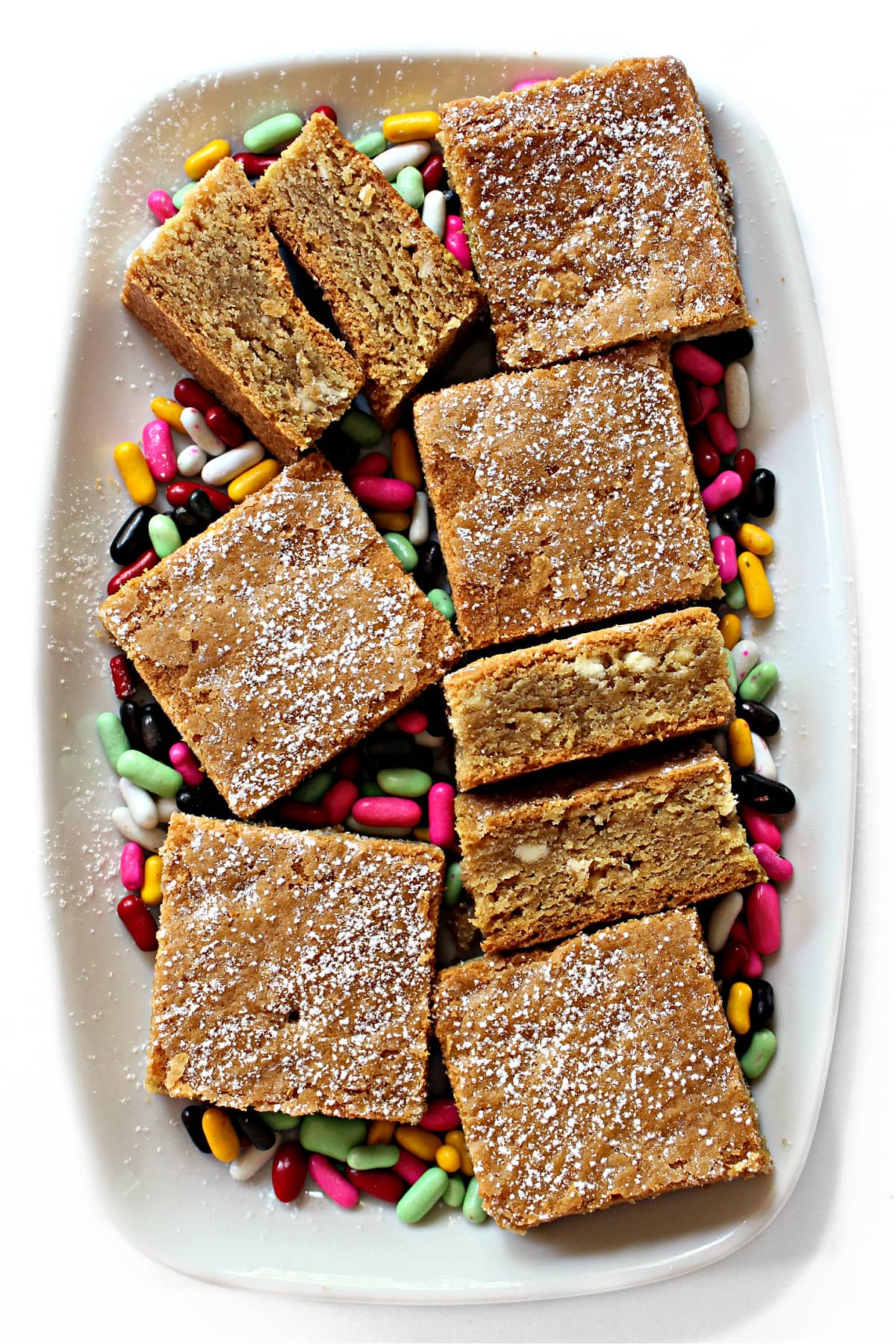 Thick, squares of Root Beer Bars dusted with powdered sugar on a serving platter.