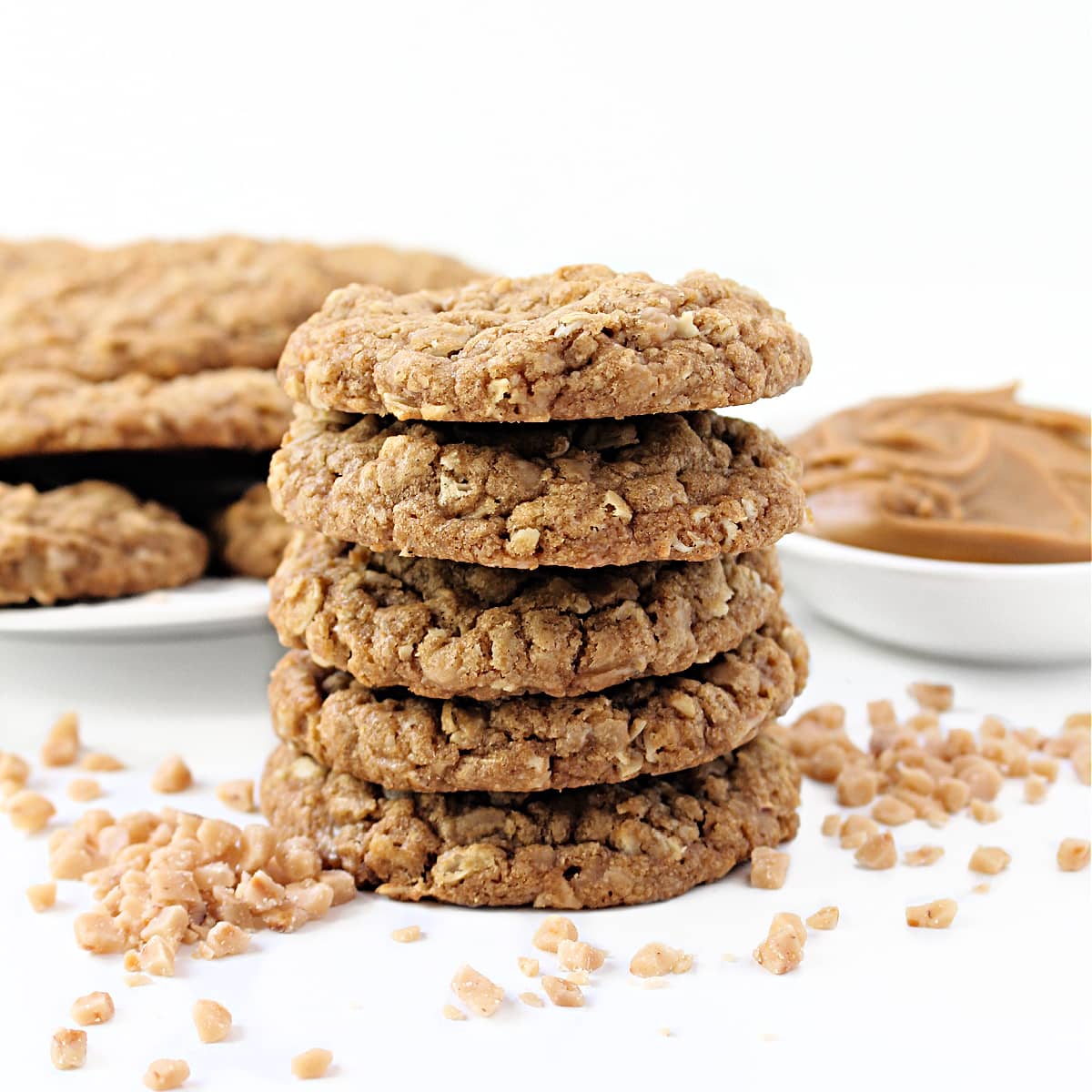 Stack of thick cookies speckled with oats and toffee bits.