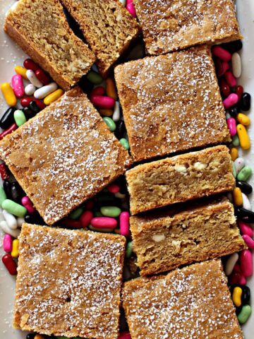 Squares of Root Beer Bars on top of licorice candies on a plate.