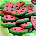 Semi-circle sugar cookies with pink and green dough look like watermelon slices.