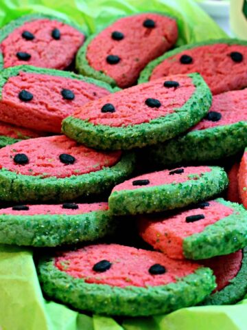 Semi-circle sugar cookies with pink and green dough look like watermelon slices.