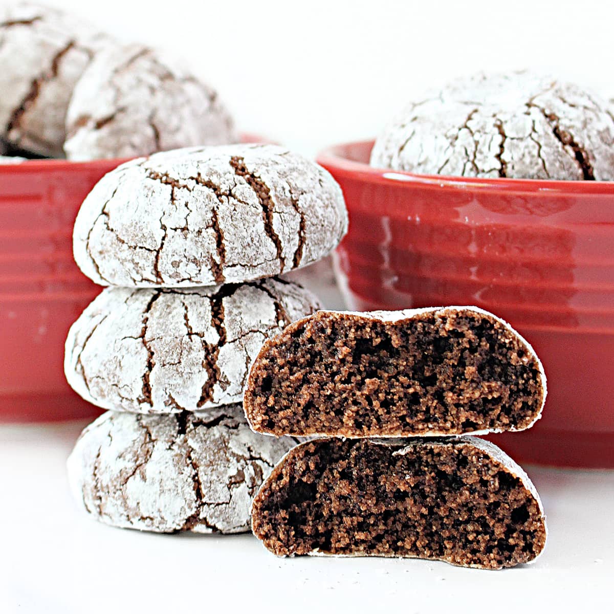 Stack of almond flour cookies with on thick cookie split in half showingchocolate crumb inside.