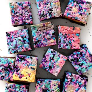 Squares of brownies topped with a multi-colored blondie layer.