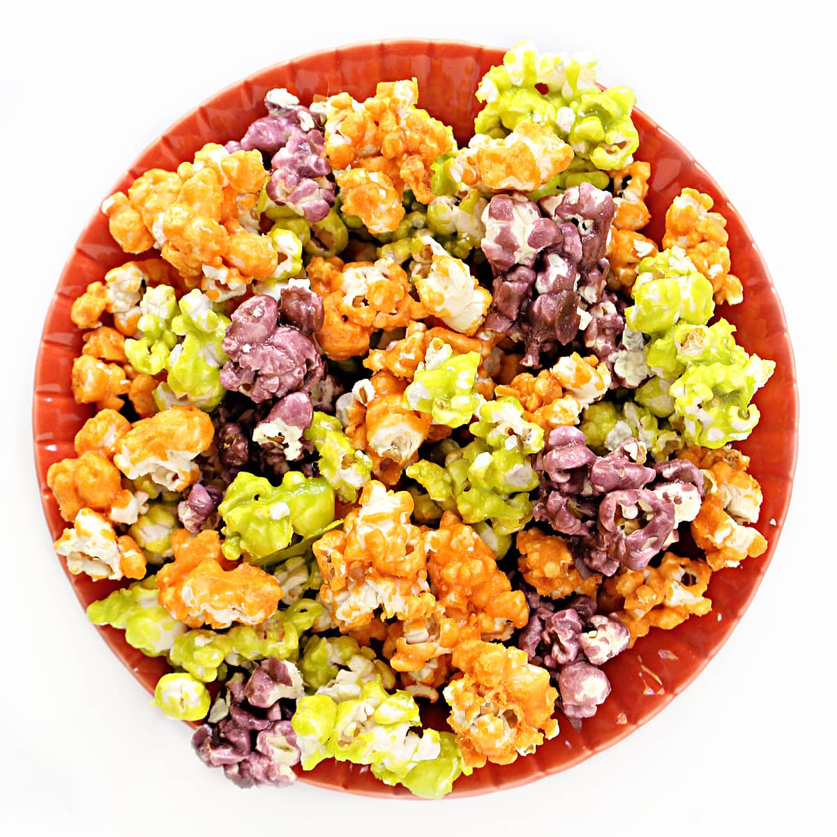 Halloween Popcorn in orange, green, and purple on a plate.