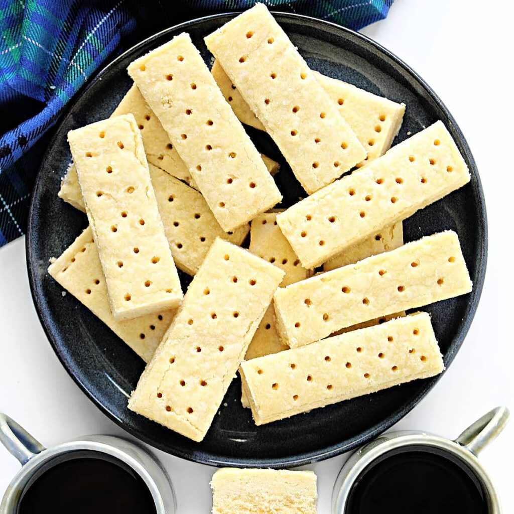 Scottish Shortbread cut into bars with holes pricked across the top of each cookie.