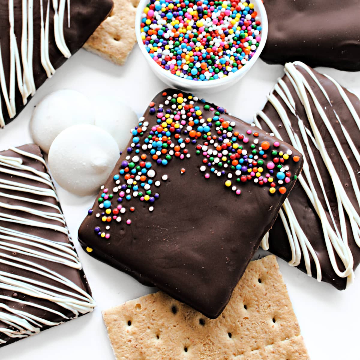 Closeup of a dark chocolate coated graham cracker with multi-colored nonpareil sprinkles.