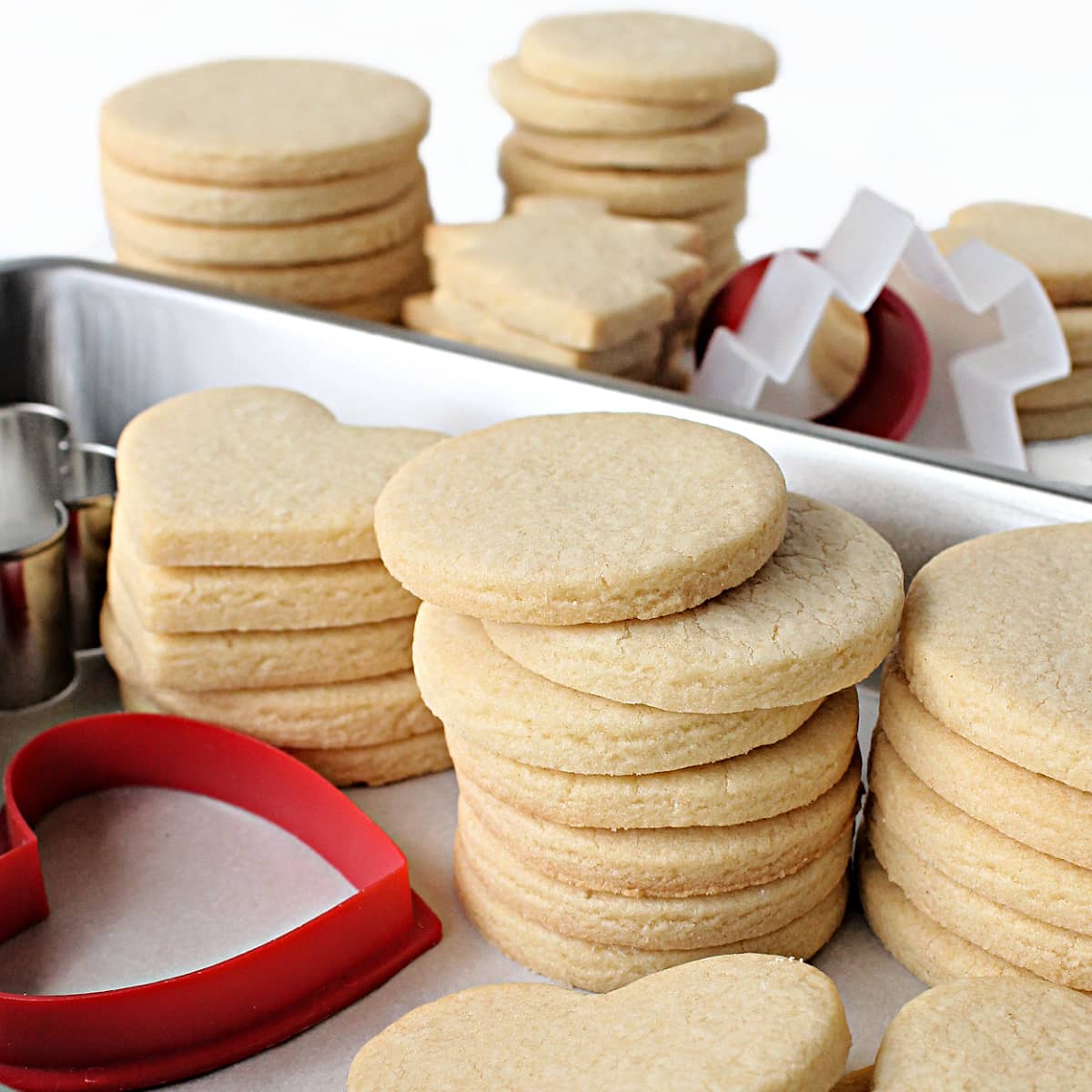 Stacks of cutout sugar cookies showing perfect no spread edges.