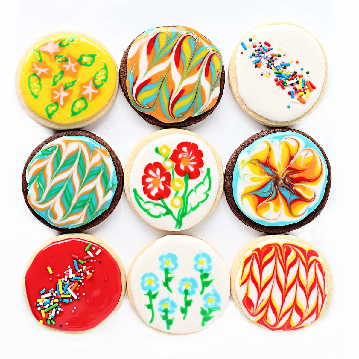 Chocolate and vanilla sugar cookie circles decorated with glaze icing designs or sprinkles.