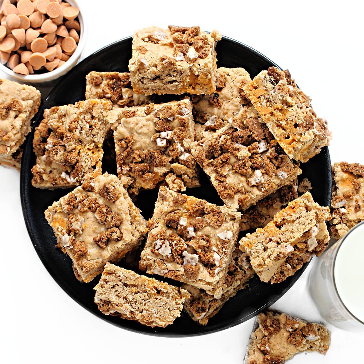 Serving plate with squares of oatmeal bars topped with bits of chopped oatmeal cookies.
