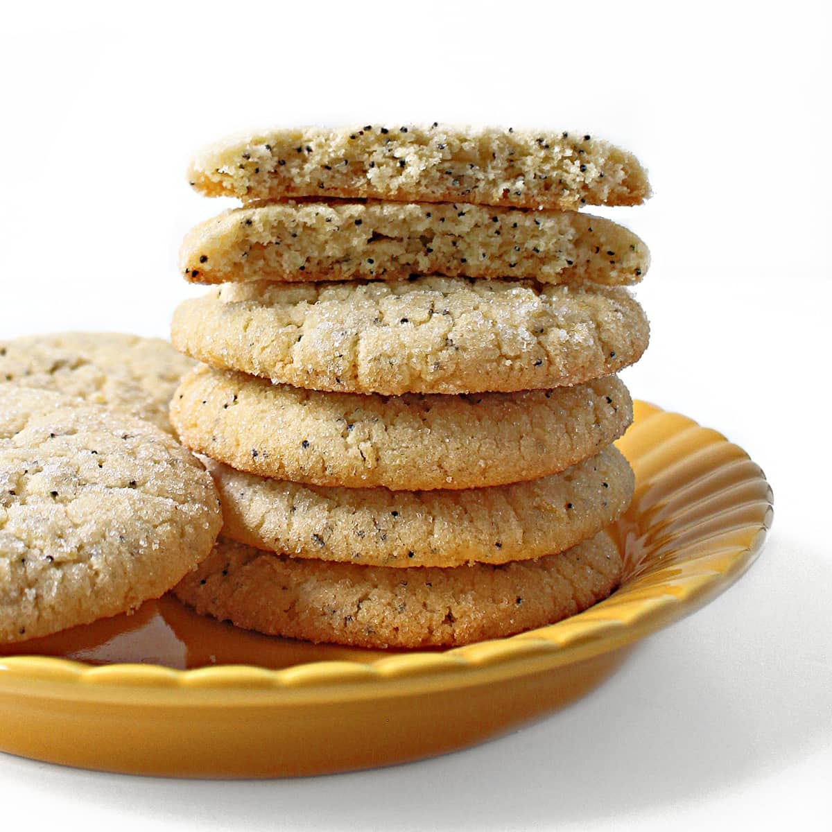 Stack of lemon cookies with poppy seeds showing crunchy edges and light, chewy interior.